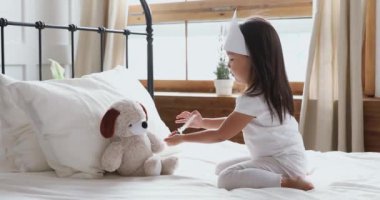 Sevimli küçük Asyalı etnik çocuk hasta doktor oyunu oynuyor..