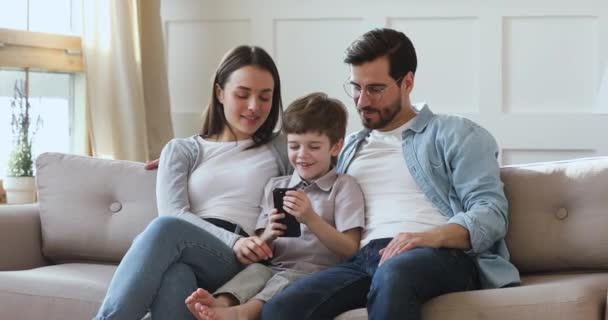 Happy little kid boy playing mobile game with parents. — Stock Video