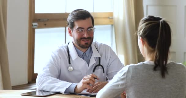 Giovane medico generico di sesso maschile che consulta una paziente di sesso femminile al check up . — Video Stock