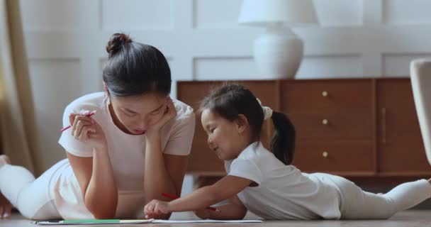 Smiling young vietnamese mother drawing pictures with cute daughter. — ストック動画
