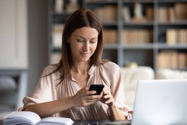 Mutlu kadın telefon ekranına bakıyor, işi başından aşkın.