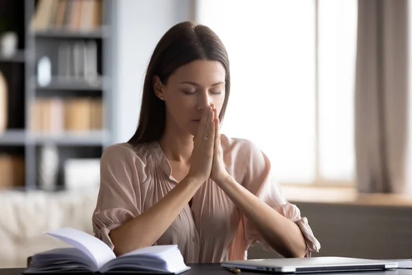 Mujer tranquila con los ojos cerrados poniendo las manos en la oración — Foto de Stock