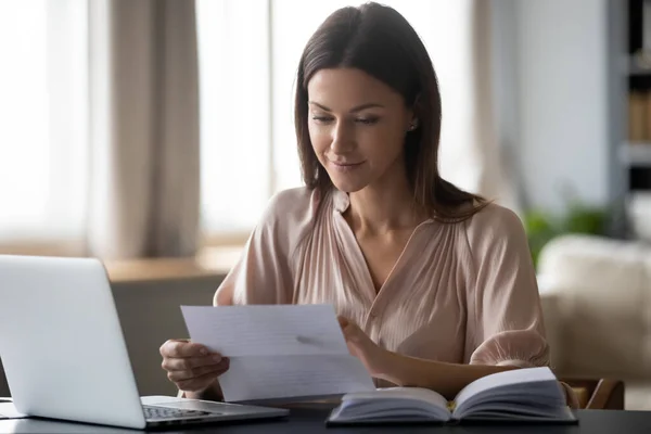 Young woman holding paper, reading good news in letter at home — Stock Photo, Image