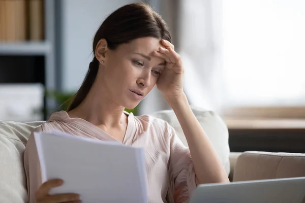Upprörd kvinna läser dåliga nyheter i brev, kollar räkningar — Stockfoto