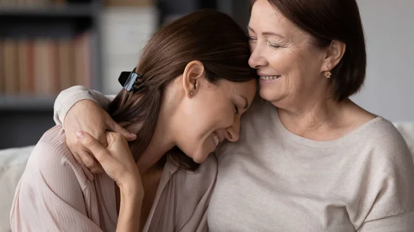 Tersenyum dewasa ibu memeluk putri dewasa, menikmati saat-saat lembut — Stok Foto