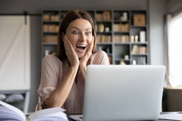 Mujer sorprendida emocionada mirando la pantalla del ordenador portátil, leyendo noticias — Foto de Stock