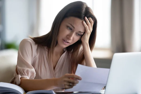 Ongelukkige vrouw die papier vasthoudt, slecht nieuws leest in brief — Stockfoto