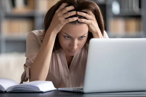 Stressé femme malheureuse regardant l'écran d'ordinateur portable, toucher la tête — Photo