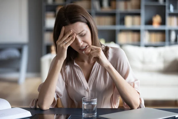 Ohälsosam kvinna som lider av huvudvärk, tar piller — Stockfoto