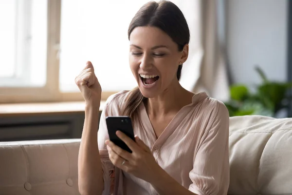 Donna eccitata guardando lo schermo del telefono e celebrando la vittoria — Foto Stock