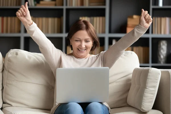 Femme mûre excitée regardant l'écran d'ordinateur portable, lisant de bonnes nouvelles — Photo