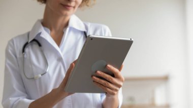 Modern ped kullanan kadın doktor dijital tablet uygulamaları kullanarak, yakın plan
