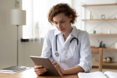 İş yerinde dijital tablet bilgisayar kullanan ciddi profesyonel doktor