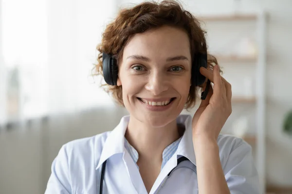 Smiling female doctor wearing headset looking at camera, portrait — Stock Photo, Image