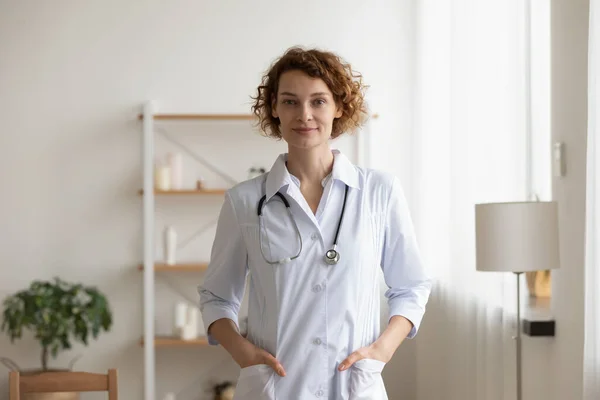 Fiducioso giovane medico donna in piedi in ufficio medico interno, ritratto — Foto Stock