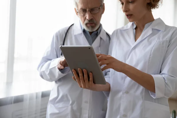 Dos médicos serios discutiendo datos usando tableta digital —  Fotos de Stock