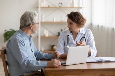 Yaşlı hastalara yaşlılık hastalıkları tedavisini açıklayan profesyonel kadın doktor