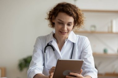 Hastanede dijital tablet kullanan genç kadın profesyonel doktor.