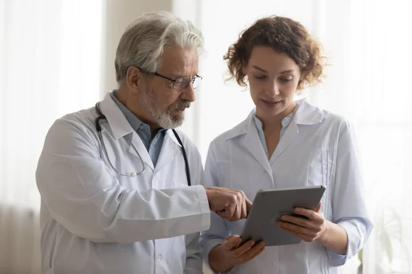 Equipo médico de dos médicos profesionales hablando con tableta digital —  Fotos de Stock