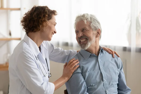 Cheerful healthy old male patient and caring doctor talking, bonding — Stock Photo, Image