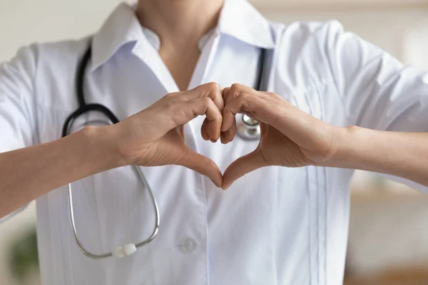 Medico cardiologo femminile che mostra le mani a forma di cuore, vista da vicino — Foto Stock