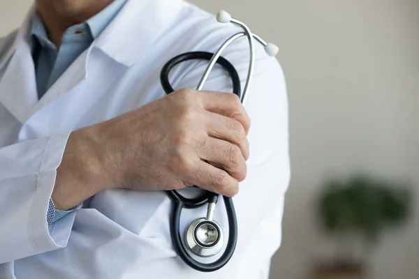 Hombre mayor médico sosteniendo estetoscopio en la mano, vista de cerca — Foto de Stock