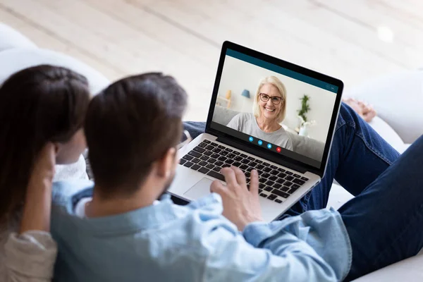Young couple talk on video call with elderly mother — Stock Photo, Image