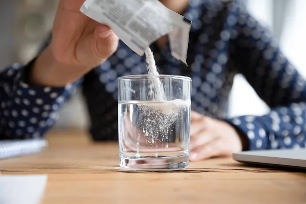 Woman pouring soluble anti-influenza powder in glass of water. — Stock Photo, Image
