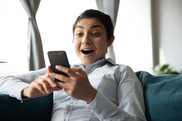 Cabeça tiro surpreendido jovem indiana olhando para tela do telefone . — Fotografia de Stock