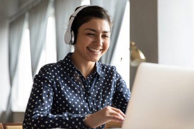 İnternette eğitim dersine katılan gülümseyen genç Hintli öğrenci.