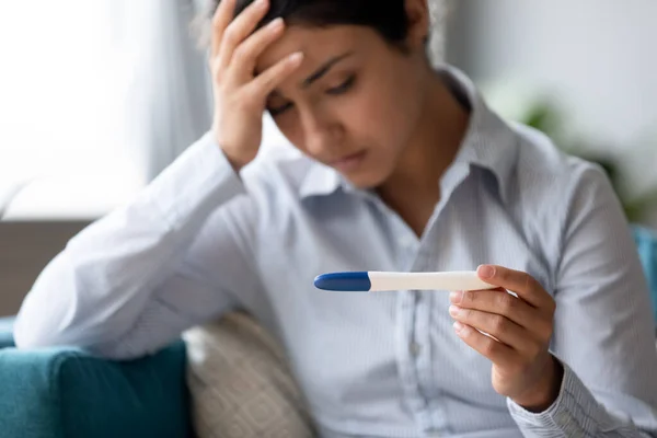 Focus on pregnancy test in hands of frustrated indian woman. — Stock Photo, Image
