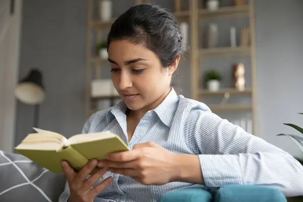 Happy focused pretty young indian woman reading book. — Stock Photo, Image