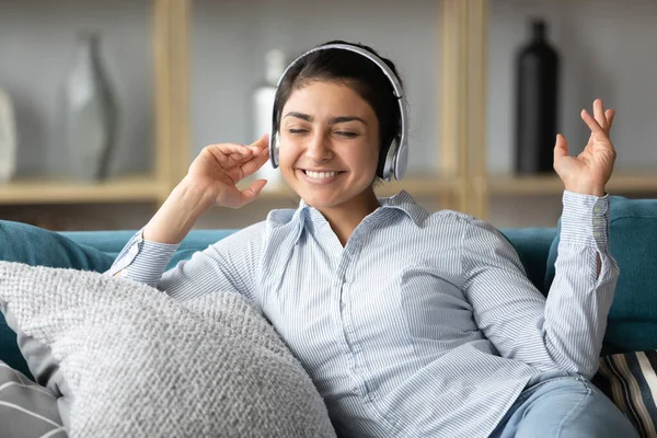 Smiling millennial indian girl listening to favorite music. — Stock Photo, Image