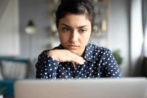 Przemyślane millenium hinduska kobieta patrząc na monitor laptopa. — Zdjęcie stockowe