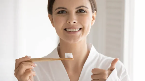 Porträtt av leende ung kvinna rekommenderar tandvård — Stockfoto