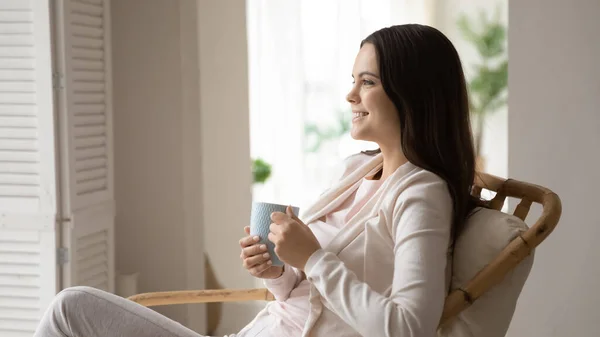 O femeie fericită se relaxează în scaun se bucură de cafea sau ceai — Fotografie, imagine de stoc