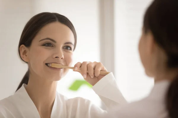 Молодая женщина чистит зубы в ванной комнате — стоковое фото