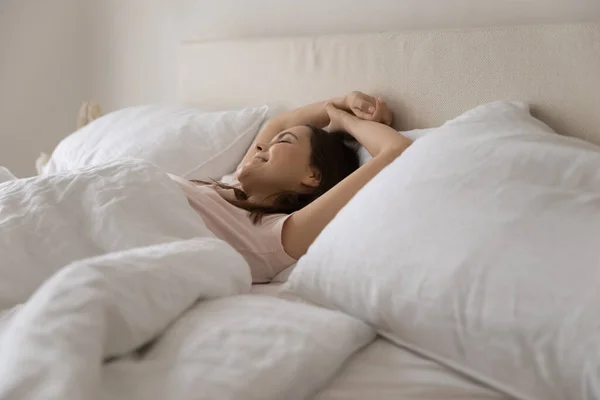 Onnellinen nuori nainen venyttää herääminen mukava sänky — kuvapankkivalokuva