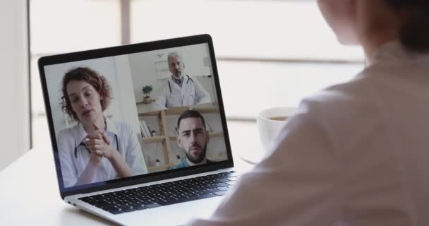 Female nurse participating young and old doctors team videoconference — Stock Video