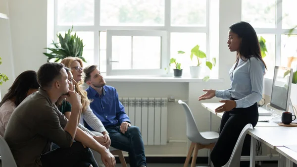 Serieuze Afro-Amerikaanse vrouwelijke leider, mentor houdt briefing voor team. — Stockfoto