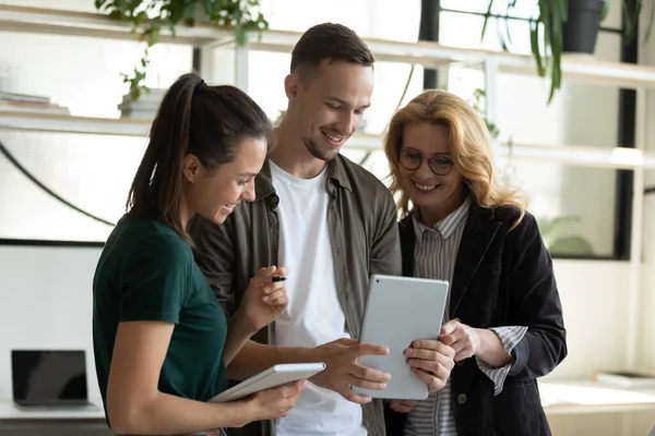 Hombre de negocios sonriente y mujer de negocios viendo video mirando la pantalla de la tableta . — Foto de Stock