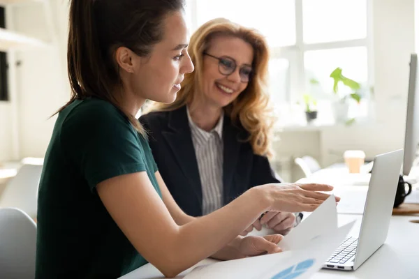 Young businesswoman presentation project using laptop for mature female mentor. — Stock Photo, Image