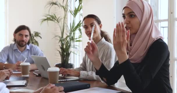 Usmívající se mladá arabka žena zaměstnankyně diskutovat pracovní problémy s kolegy. — Stock video