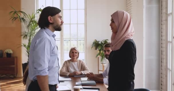 Glücklicher junger bärtiger Manager schüttelt lächelnden arabischen Angestellten die Hand. — Stockvideo