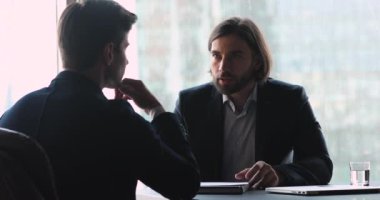 Odaklanmış başarılı iş adamı, ortakla sözleşme detaylarını tartışıyor