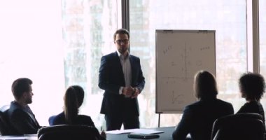 Kendine güvenen erkek konuşmacı iş projesi fikirlerini ters yüz etmek üzere sunuyor.