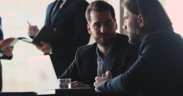 Empregados masculinos concentrados discutindo detalhes do projeto em escritório compartilhado . — Vídeo de Stock