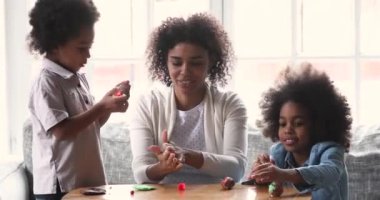 Mutlu Afro-Amerikan çocukları anneleriyle plastikle şekiller yapıyor..