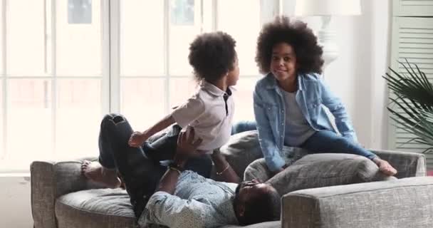 Heureux enfants africains ethniques frères et sœurs faisant des exercices avec un père fort . — Video