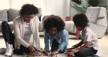Mutlu Afrikalı anne evde çocuklarla oyuncak oynuyor..
